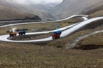 Вантажівки на дорозі в гірському ландшафті Тибету (Китай). — стокове фото