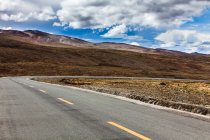 Дорога з гірським видом і хмарним небом, Тибет, Китай — стокове фото