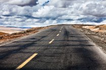Road with cloudy sky, Tibet, China — Stock Photo