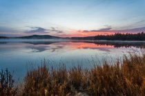 Lago com reflexão céu por do sol e montanhas — Fotografia de Stock