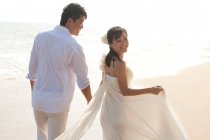 Glückliches chinesisches Brautpaar am Strand — Stockfoto