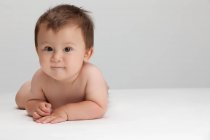 Studio shot of a cute Chinese baby boy lying on his front — Stock Photo