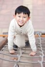 Ragazzo cinese scalata parco giochi scaletta corda — Foto stock