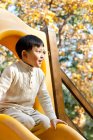 Chinese boy playing on playground slide — Stock Photo