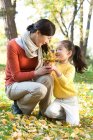 Chinesische Mutter und Tochter sammeln Blätter — Stockfoto