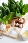 Garlic, Mushrooms and Bok Choy on cutting board — Stock Photo