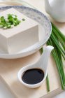 Tofu em tigela com molho de soja e cebola verde — Fotografia de Stock