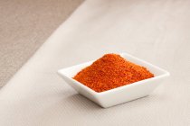 Square bowl of chili pepper spice, close up shot — Stock Photo