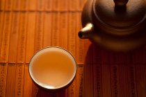 Chá na xícara e panela no tapete de madeira — Fotografia de Stock