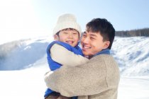 Chinese father playing with son in snow — Stock Photo