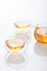 Set de té de vidrio con olla y té en tazas aisladas sobre fondo blanco - foto de stock
