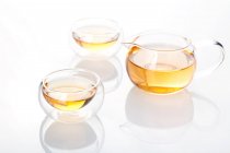 Conjunto de chá de vidro com panela e chá em copos isolados no fundo branco — Fotografia de Stock