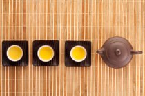 Conjunto de chá no tapete de bambu, vista superior da panela e xícaras — Fotografia de Stock