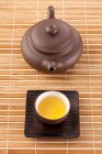 Tazza di tè e pentola sul tappetino di bambù, colpo da vicino — Foto stock