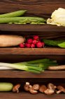 Varias verduras frescas en estante de madera - foto de stock