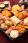 Chinese traditional dim sum and preserved fruit served on wooden tray — Stock Photo