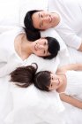 Felice famiglia cinese sdraiata a letto — Foto stock