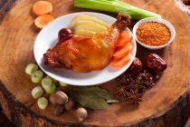 Braised chicken on plate surrounded with ingredients — Stock Photo