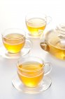Set da tè in vetro con pentola e tè in tazze isolate su sfondo bianco — Foto stock