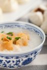 Bowl of rice porridge and steamed buns served on table — Stock Photo