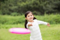 Menino chinês feliz jogando frisbee — Fotografia de Stock