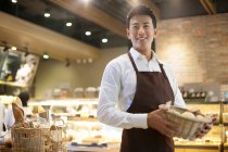 Giovane uomo cinese che lavora in panetteria — Foto stock