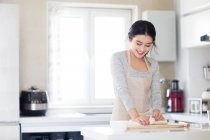 Красивая молодая женщина готовит печенье на кухне — стоковое фото