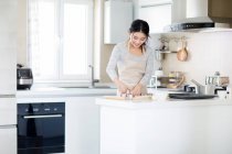 Bela jovem mulher cozinhar biscoitos na cozinha — Fotografia de Stock