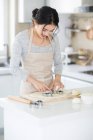 Beautiful young woman cooking cookies at kitchen — Stock Photo