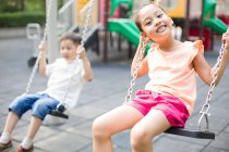 Happy Chinese girl on swing — Stock Photo