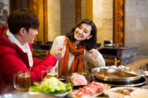 Young Chinese couple having dinner in hotpot restaurant — Stock Photo