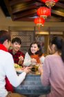 Young Chinese friends having dinner in hotpot restaurant — Stock Photo