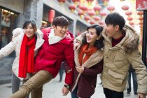 Молодые китайские друзья идут вместе по улице — стоковое фото