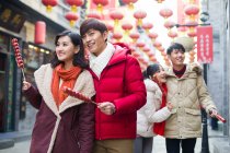 Giovani amici cinesi con bacche di haw candite che celebrano il capodanno cinese — Foto stock