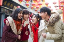 Молодые китайские друзья с засахаренными ягодами мясорубки празднуют китайский Новый год — стоковое фото