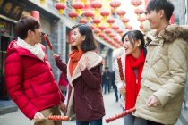 Giovani amici cinesi con bacche di haw candite che celebrano il capodanno cinese — Foto stock