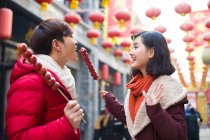 Joven pareja china con bayas de haw confitadas celebrando el Año Nuevo Chino - foto de stock