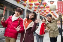 Jeunes amis chinois avec des baies confites célébrant le Nouvel An chinois — Photo de stock