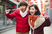 Молоде китайське подружжя з консервованими ягодами святкує китайський Новий рік — стокове фото