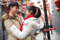 Junges chinesisches Paar mit kandierten Haw-Beeren feiert chinesisches Neujahr — Stockfoto