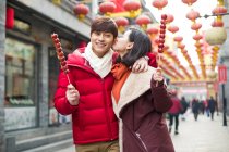 Молодая китайская пара с засахаренными ягодами из сена празднует китайский Новый год — стоковое фото