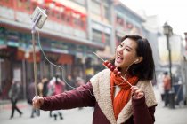 Giovane donna cinese scattare autoritratto con uno smartphone — Foto stock
