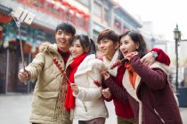 Jóvenes amigos chinos tomando autorretrato con un teléfono inteligente - foto de stock