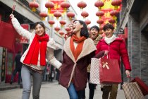 Счастливые молодые китайские друзья делают покупки на Новый год по-китайски — стоковое фото