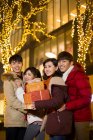 Jovens amigos chineses felizes com presentes de ano novo — Fotografia de Stock