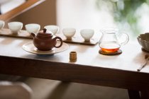 Chinese tea pots and tea cups in row — Stock Photo