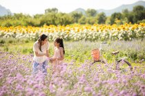 Китайська мати й дочка на квітковому полі. — стокове фото