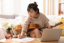 Frau lernt zu Hause Gitarre spielen — Stockfoto