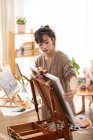 Giovane donna cinese che si prepara per la pittura a casa — Foto stock