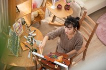 Young chinese woman painting at home — Stock Photo